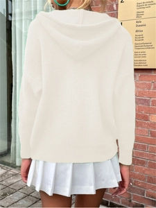 Detailed knit texture of cream hooded cardigan paired with white pleated mini skirt