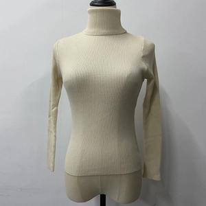 Detail of cream high-neck ribbed sweater showing vertical knit texture and slim fit design
