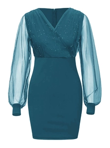Detailed close-up of teal V-neck dress with sheer sequined sleeves and star-like texture