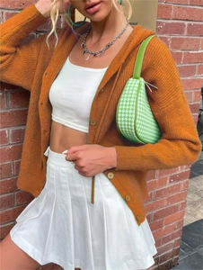Detail of caramel orange ribbed knit cardigan featuring round buttons and vertical texture