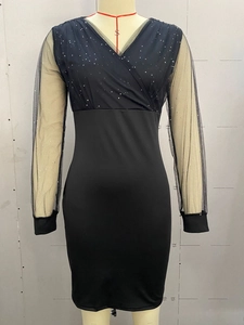 Close-up of black mesh sleeves and sparkling sequin V-neck bodice on a slim evening dress