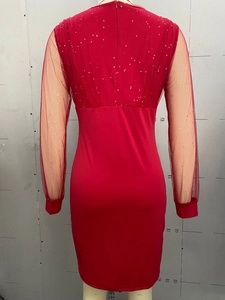 Detail view of red sequined dress with mesh sleeves and invisible back zipper