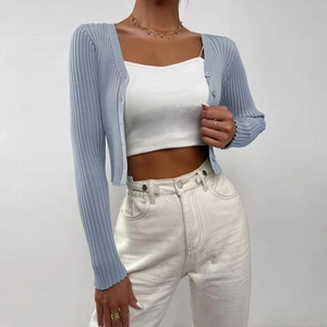 Detailed close-up of light blue knit cardigan featuring vertical ribbed texture and buttons