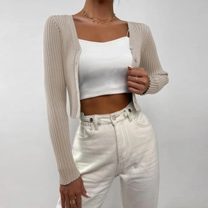 Detailed texture of beige ribbed knit cardigan with matching buttons on front