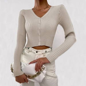 Macro shot of the ribbed texture and buttons on a beige V-neck knitted cardigan
