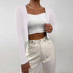 Close-up detail of white ribbed knit cardigan with matching buttons and cropped fit