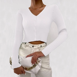 Close-up of white ribbed knit cardigan with button closure and refined vertical texture