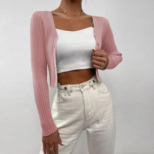 Detail of pink ribbed knit texture and matching buttons on women's cropped cardigan