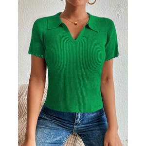 Détail d'un polo en maille vert émeraude à manches courtes avec texture côtelée et volants