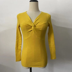Detail of yellow V-neck knit sweater featuring front twist knot and ribbed texture fabric