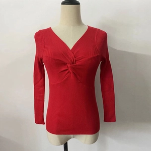 Macro detail of the twist-front design and ribbed knit texture on the red V-neck sweater