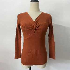Detail of cross V-neck knit sweater featuring twist knot decoration and ribbed texture