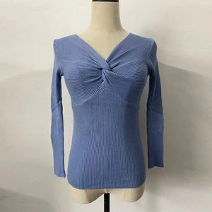 Detail of light blue ribbed knit sweater featuring a stylish twist V-neck and long sleeves