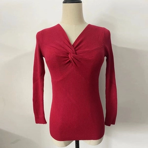 Detail of the red V-neck cross-over twist design on a ribbed knit sweater top