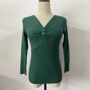 Detail of dark green ribbed knit sweater featuring a stylish twisted V-neck design