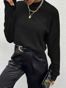 Minimalistischer schwarzer Rundhals-Strickpullover für Damen auf weißem Hintergrund präsentiert