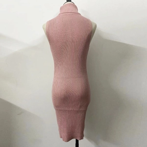 Détail d'une robe en tricot rose sans manches à col roulé montrant la texture côtelée ajustée