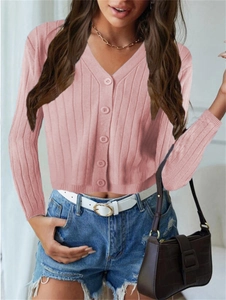 Détail du cardigan en maille côtelée rose avec col en V et fermeture à boutons assortis