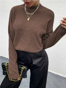 Detailansicht eines tiefbraunen Strickpullovers mit überschnittenen Schultern und Textur