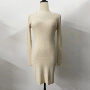 Dettaglio dello scollo a V smerlato e della trama in maglia a coste su un abito beige