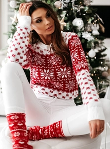 Détail d'un pull de Noël rouge et blanc avec motifs de flocons et chaussettes assorties