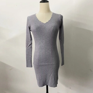 Dettaglio dello scollo a V con bordo ondulato su un abito in maglia a costine grigio