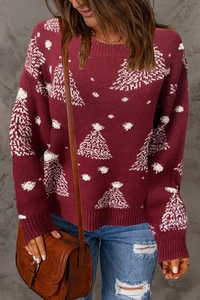 Détails des motifs festifs de sapin de Noël et flocons de neige sur pull en maille rouge