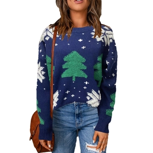 Detail of navy Christmas sweater with green pine trees and white snowflake patterns