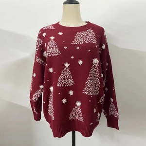 Détail du pull de Noël rouge avec motifs de flocons blancs et col rond en maille côtelée
