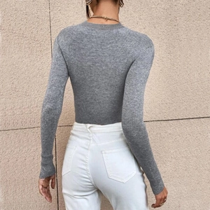 Close-up of gray long sleeve ribbed knit sweater with a slim fit cropped design