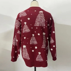 Détail d'un pull de Noël rouge avec sapins en tricot blanc et pompons en peluche 3D