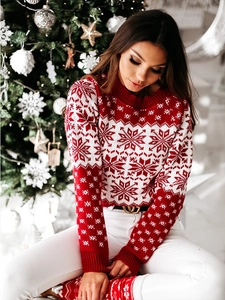 Détail du pull de Noël en tricot avec motifs de flocons de neige et finitions côtelées