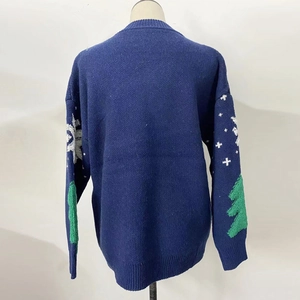 Detail of dark blue knit sweater featuring Christmas tree patterns and ribbed cuffs