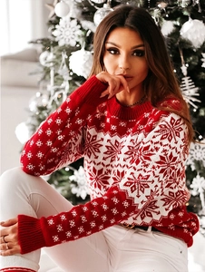 Détail du pull de Noël en tricot avec des motifs de flocons de neige blancs sur tissu rouge