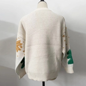 Detail of festive Christmas knit sweater showing cream white texture and holiday motifs