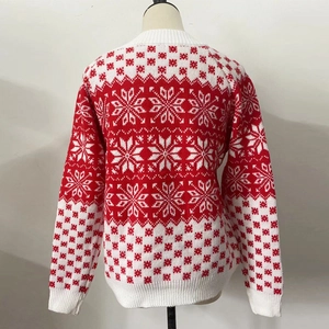 Détail du pull de Noël en tricot rouge et blanc avec motifs de flocons et géométriques