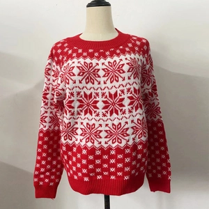 Détail du pull de Noël rouge présentant des motifs de flocons de neige et vagues en tricot blanc