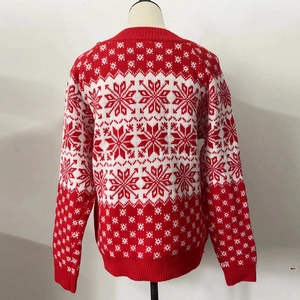 Gros plan du pull en maille d'hiver avec des motifs classiques de flocons rouges et blancs