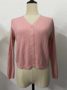 Détail du cardigan en maille rose montrant le col en V et la texture côtelée