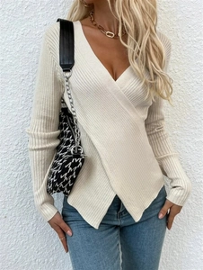 Détail d'un pull en maille crème à manches longues avec texture côtelée et col en V croisé