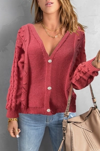 Close-up of V-neck red knit cardigan with textured cable knit sleeves and white buttons