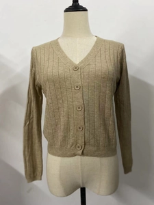 Détails de la maille côtelée verticale et des boutons assortis sur ce gilet de couleur camel