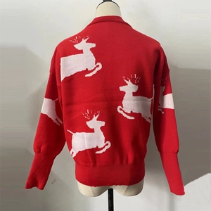 Macro shot of knitted reindeer pattern and thick ribbed hem on red Christmas sweater