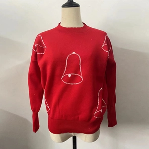Close-up of red Christmas knit sweater featuring white bell patterns and ribbed neck