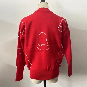 Detail of red Christmas knit sweater featuring white bell pattern and ribbed cuffs