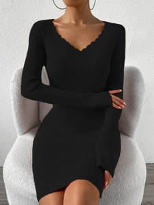 Détail de la robe mini en maille côtelée noire avec col en V festonné et texture moulante