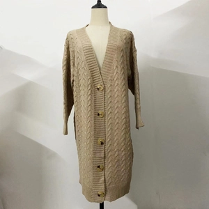 Detail of cable knit texture and brown buttons on beige long cardigan sweater