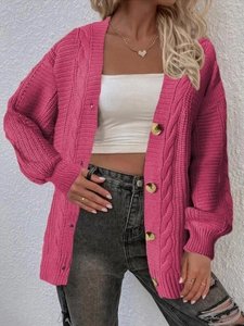 Detail of chunky cable knit cardigan in magenta with decorative gold buttons