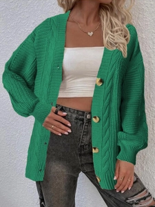 Detail of green knit cardigan featuring chunky cable knit texture and large buttons