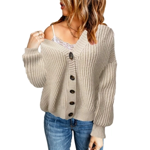 Detailed view of beige chunky knit cardigan with oversized brown buttons and V-neckline